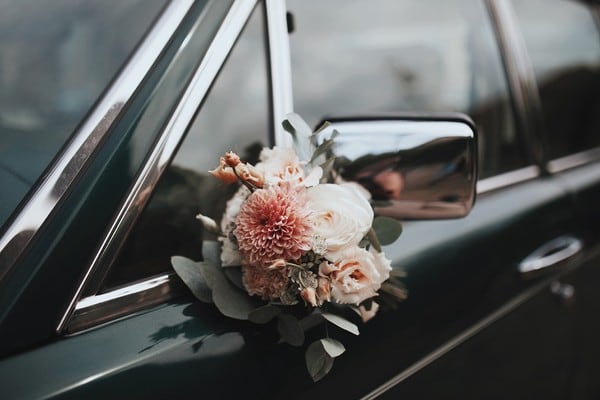 Bouquet floral attaché à une voiture de mariage